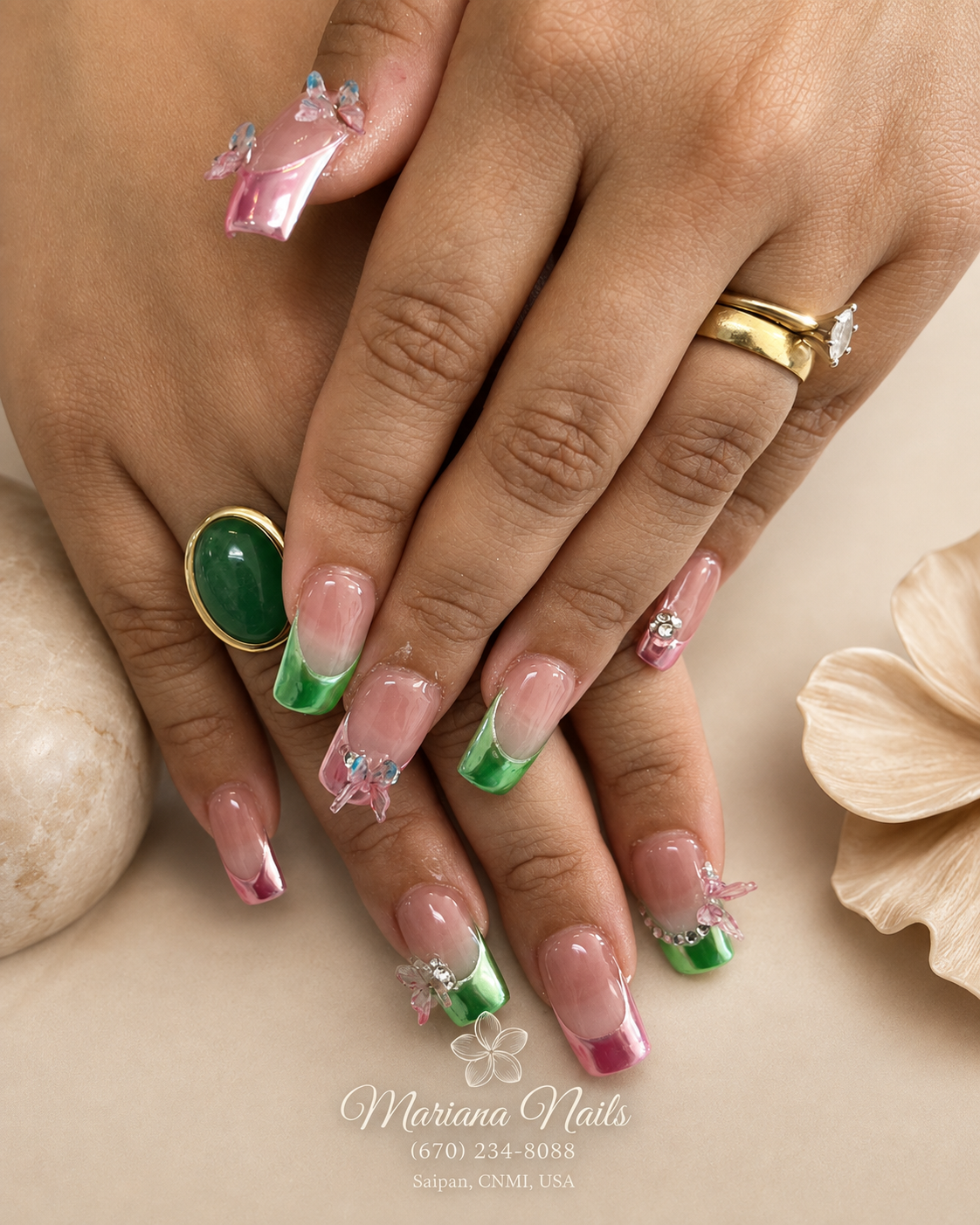 Glossy nude square acrylic nails with green and pink French tips, rhinestone accents and 3D butterfly charms by Mariana Nails in Saipan