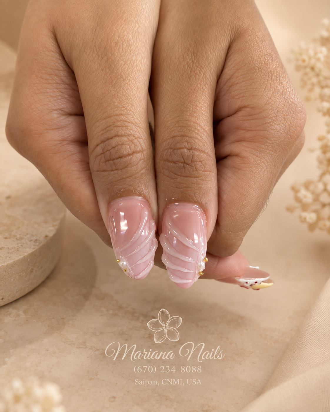 Soft pink almond nails with white wave nail art and delicate gold floral accents by Mariana Nails in Saipan