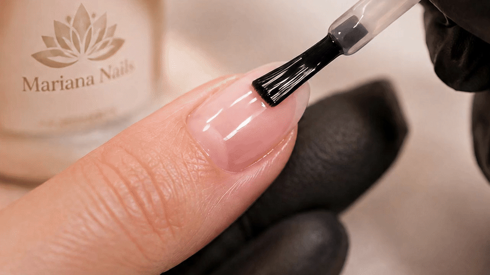 Close-up of nude pink gel polish being applied during a manicure at Mariana Nails in Saipan